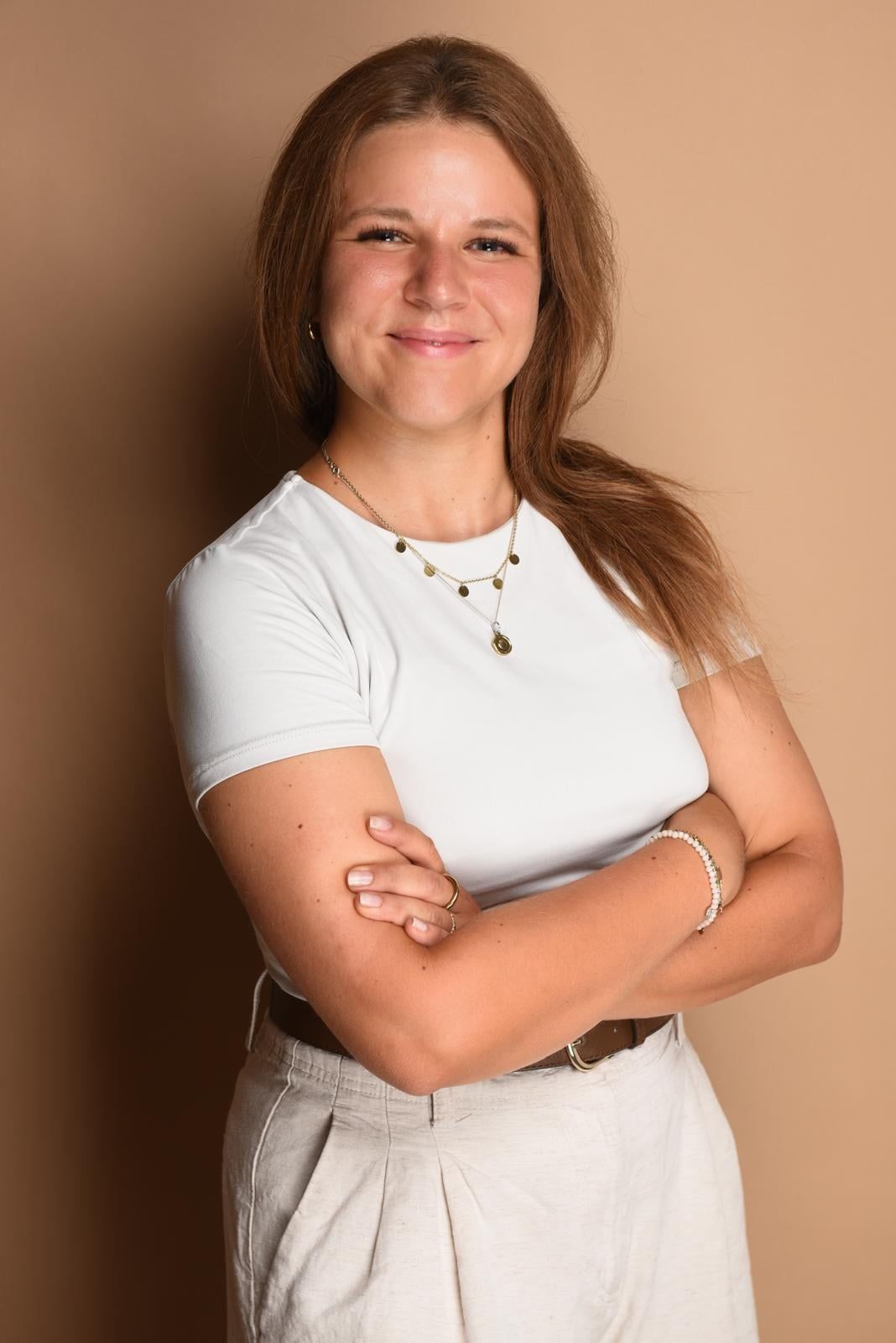 Natascha Kocher, Physiotherapeutin, mit verschränkten Armen vor beigem Hintergrund