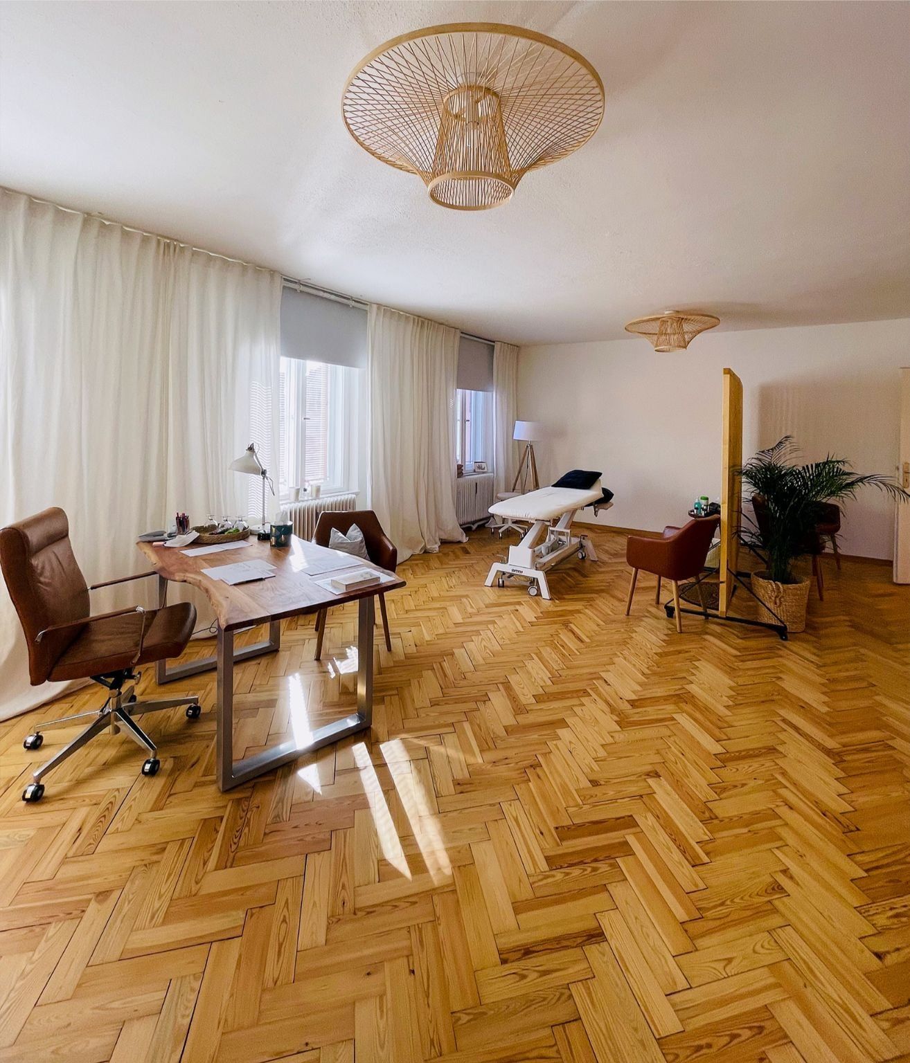 Praxisraum für Mental-Training Praxisraum mit Schreibtisch, Sesseln und Therapieliege auf Fischgrätparkett